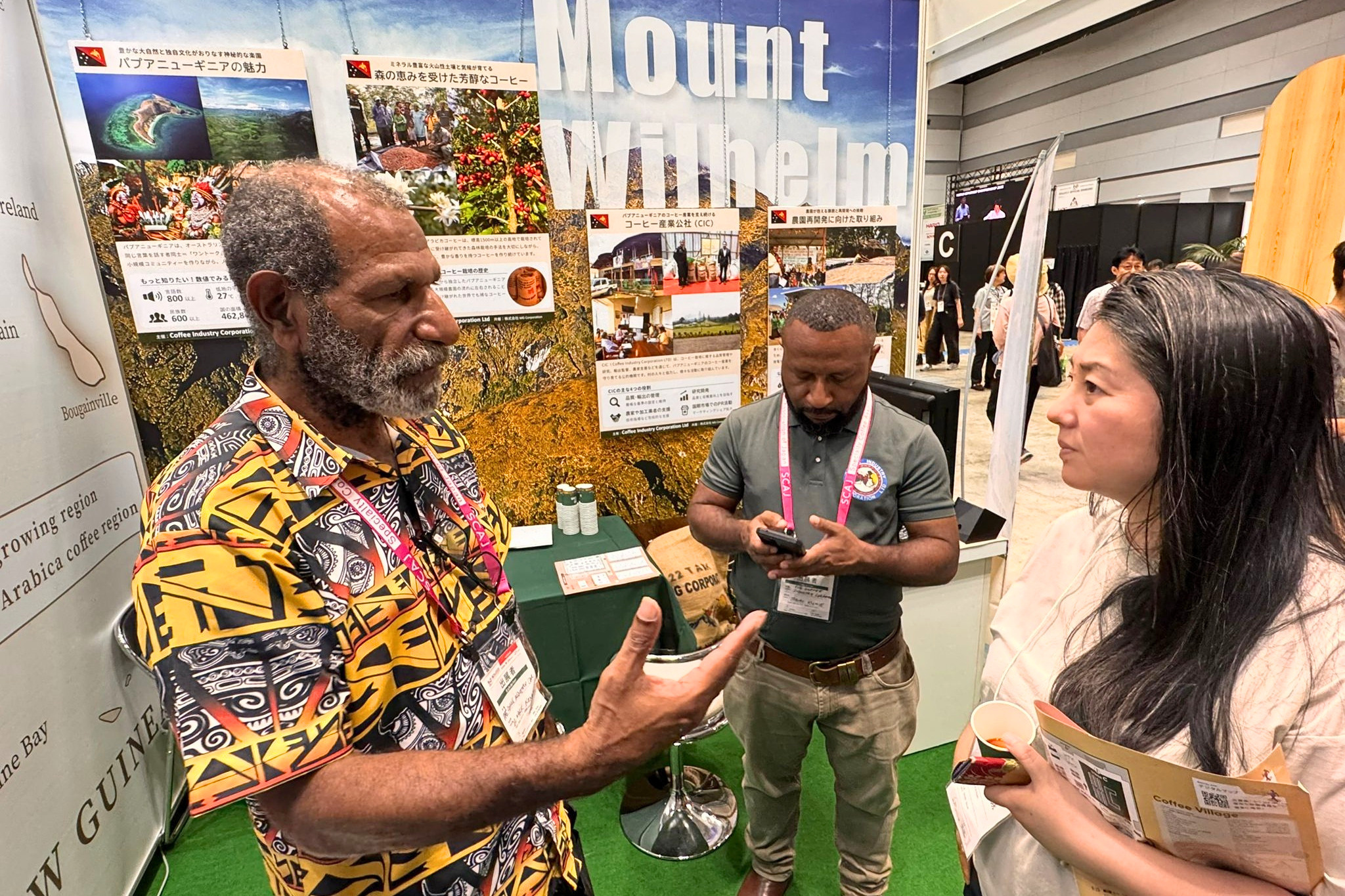 Explaining Papua New Guinea coffee cultivation and processing practices to visitors at SCAJ 2025